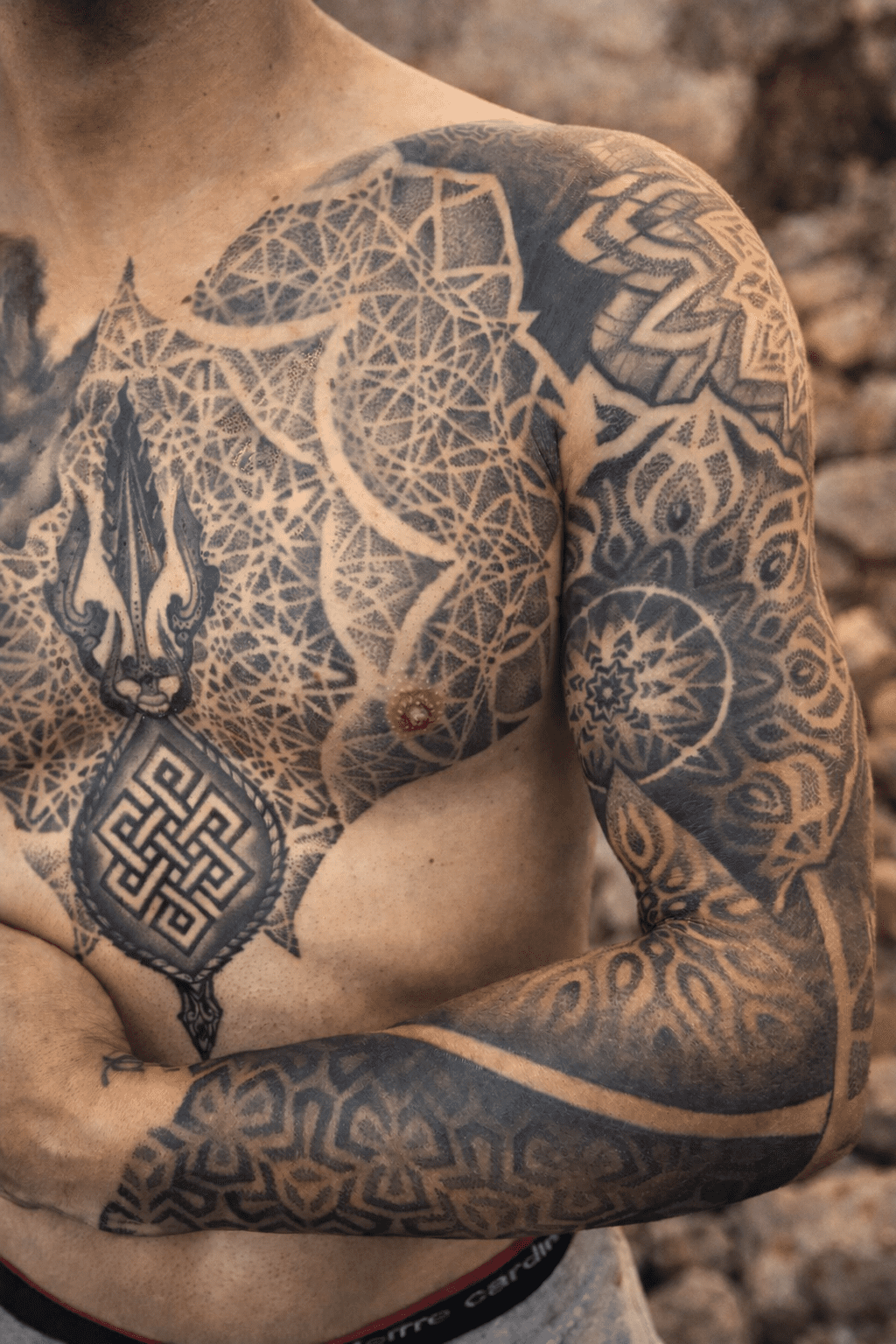 Tatuaje de pecho y brazo masculino con geometría sagrada, hecho en dotwork en Tinta Canaria Studio, Las Palmas.