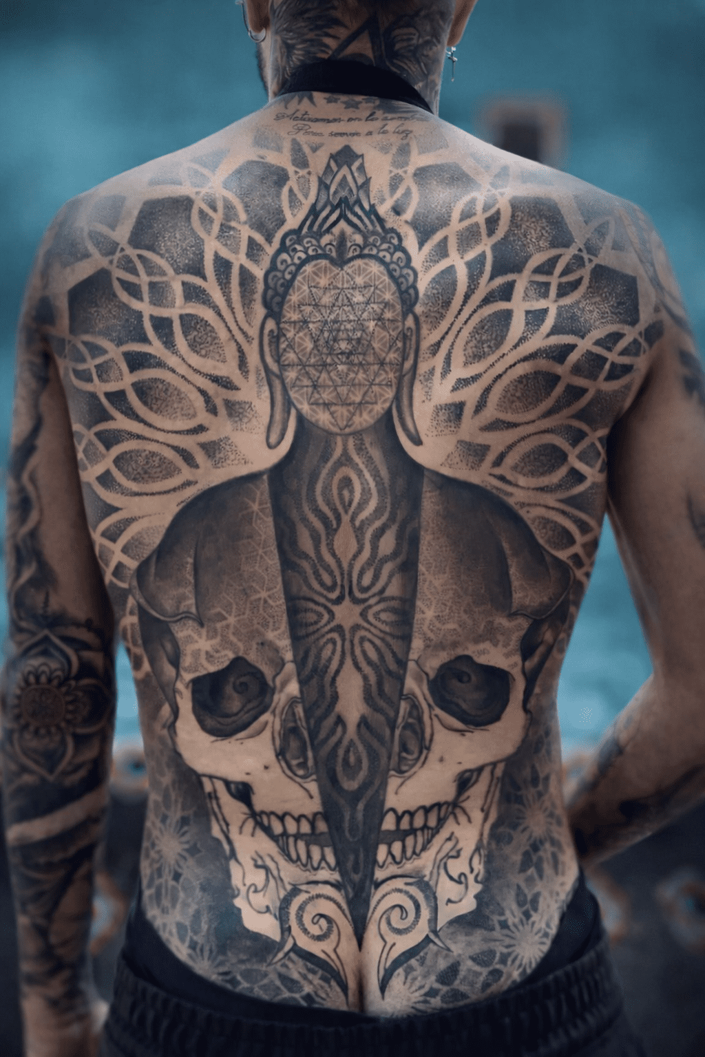Tatuaje en puntillismo de espalda masculina con Buda y calavera, creación personal de la artista GuaciMara en Tinta Canaria Studio